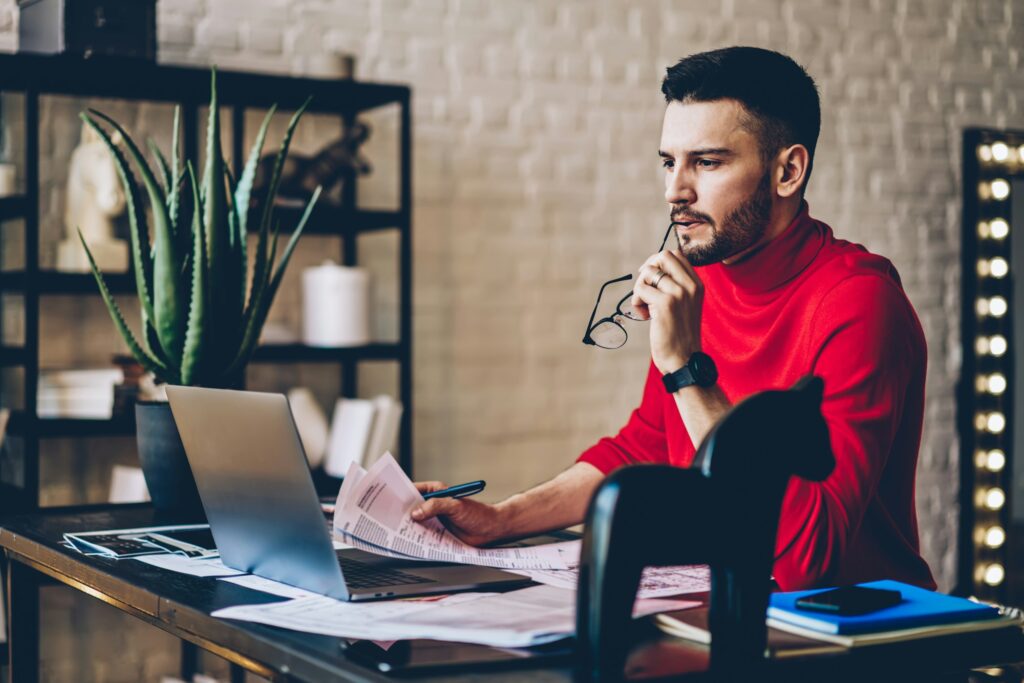Caucasian man with accounting paperwork reading publication